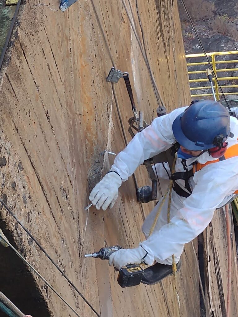 Trabalhador faz injeção de material em concreto