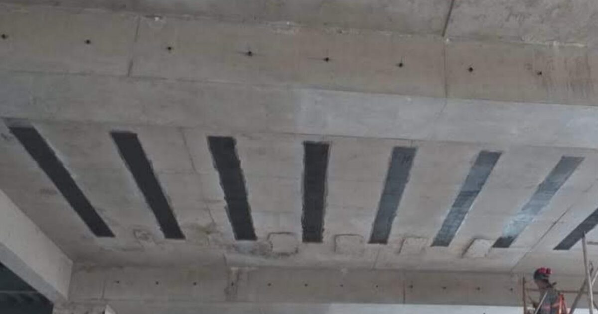 Funcionário aplica fibra de carbono em estrutura de concreto